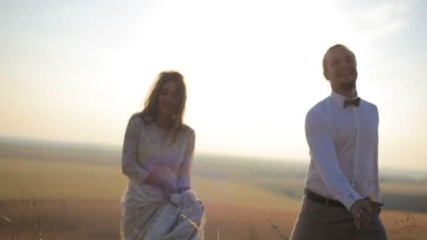Güzel adam ve kız güzel bir kırsal manzara zemin karşı bir gün aşkına alan boyunca yürüyüş. — Stok video