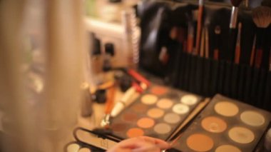 Makyöz kozmetik çantası üzerinden alır. Profesyonel kozmetik makyaj sanatçısı bir bavul. Çok renkli ruj, gölgeler, makyaj durumda Vakfı.