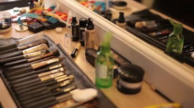 Profesyonel kozmetik makyaj stüdyo tablo. Çok renkli ruj, gölgeler, bir temel bir makyaj içinde. Profesyonel makyaj fırçaları bir deri çanta. Bir makyaj paleti fırça ile kullanma