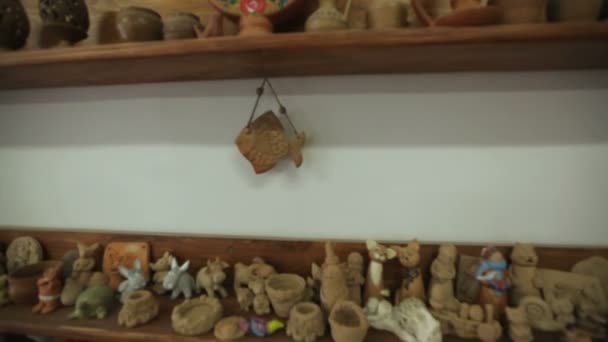 Juguetes y souvenirs de arcilla en estantes en taller — Vídeos de Stock