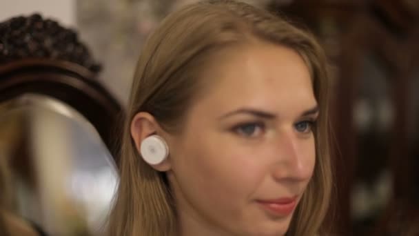 Porträtt av vacker kvinna med trådlösa hörlurar. Söt flicka ler. — Stockvideo