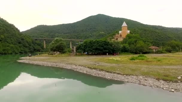 Vista aérea de un castillo sobre un telón de fondo de pintorescas montañas y un río — Vídeos de Stock