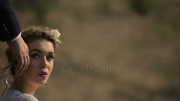 Hermoso chico y chica están descansando en el campo al atardecer del día sobre el telón de fondo de un pintoresco paisaje rural . — Vídeos de Stock