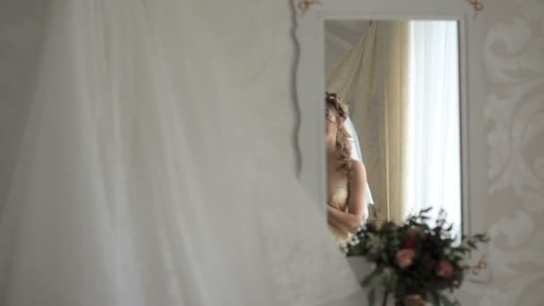 Sposa felice ammira il suo abito da sposa nella stanza. Giorno del matrimonio . — Video Stock