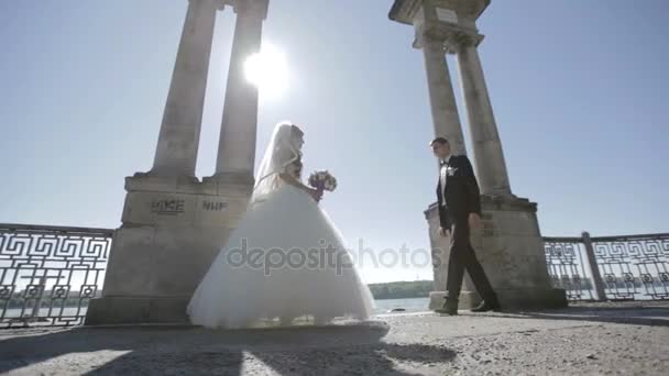 Taniec weselny. dzień ślubu. Nowożeńcy tańczą na nabrzeżu. taniec pary młodej, w pobliżu malowniczego jeziora niebieski — Wideo stockowe
