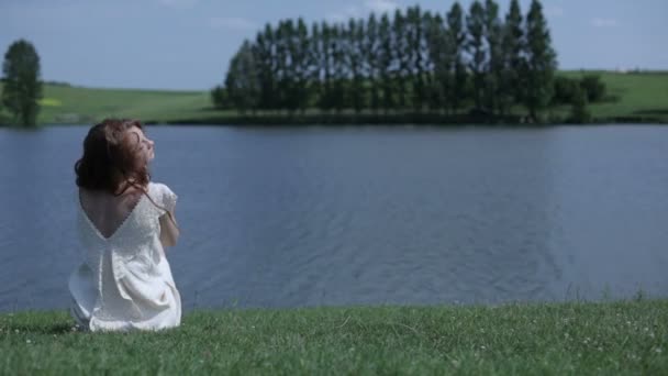 Red-haired girl on the bank of the river — Stock Video