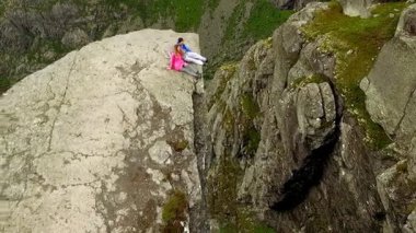 Norveç. adam ve Trolltunga kenarında oturan kız