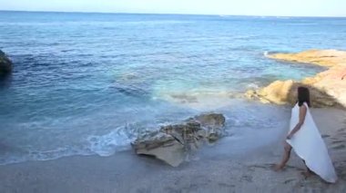 Bir deniz kıyısı uzun beyaz bir elbise güzel kadın