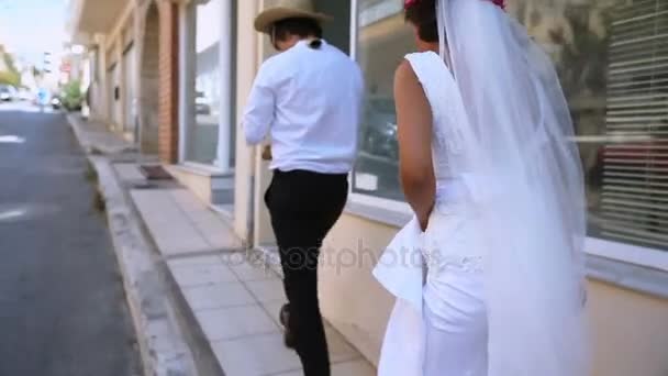 Newlyweds walking along the old street of Greece — 비디오