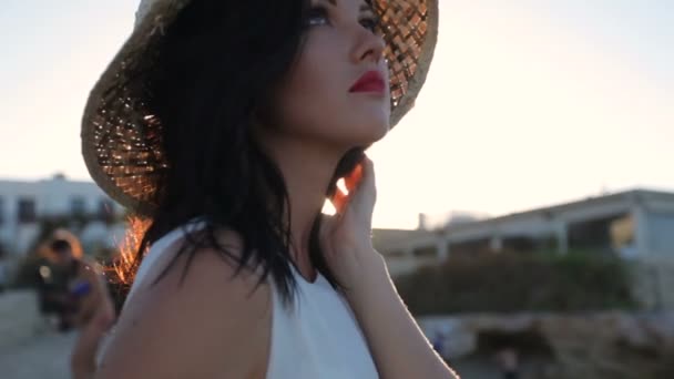 Beautiful girl stands on the seashore in the rays of the rising sun. Greece — Stock Video