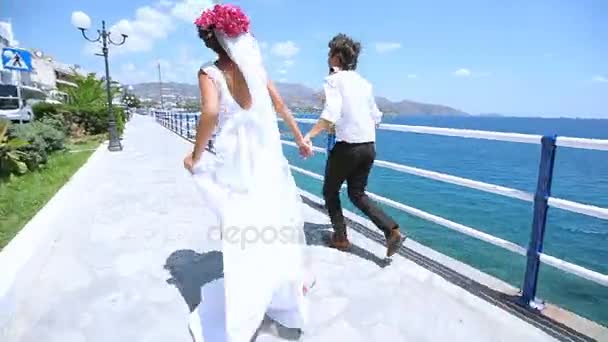 Молодята біжать уздовж набережної. День весілля . — стокове відео