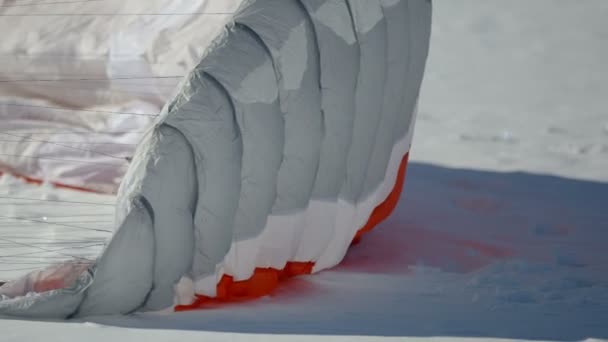 Voorbereiding voor paragliding competitie. parachute ligt in de sneeuw. — Stockvideo