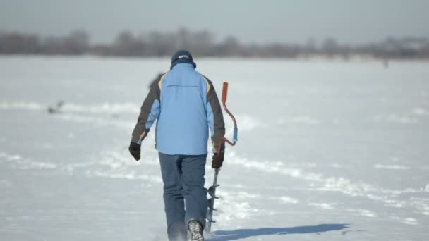 Fishermen on ice on a frozen lake near the city park — Stock Video