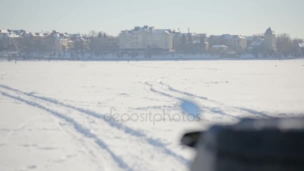 Motorschlitten auf dem zugefrorenen See. Blick auf die Instrumententafel eines Motorschlittens mit der Flagge der Ukraine im Hintergrund einer Winterstadt. — Stockvideo
