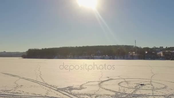 凍った湖の空撮。町の近くの凍った湖の空中写真 — ストック動画