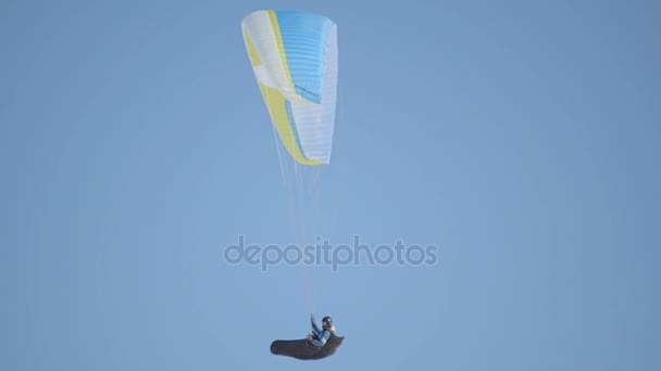 A pilóta a siklóernyő az lebeg a levegőben. Kísérleti siklóernyő ellen a kék ég — Stock videók