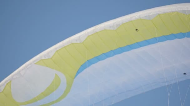 Fallschirm Fallschirm gegen den blauen Himmel. Winterspaß Gleitschirmfliegen aus der Luft — Stockvideo