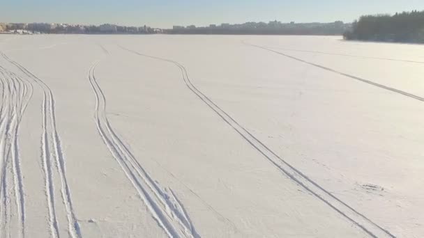 Winterpret. Een tocht op een sneeuwscooter. Twee jongens zijn een sneeuwscooter rijden over bevroren meer ijs — Stockvideo