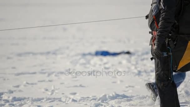 Preparation for winter paragliding competition on a frozen lake near the city park. — Stock Video