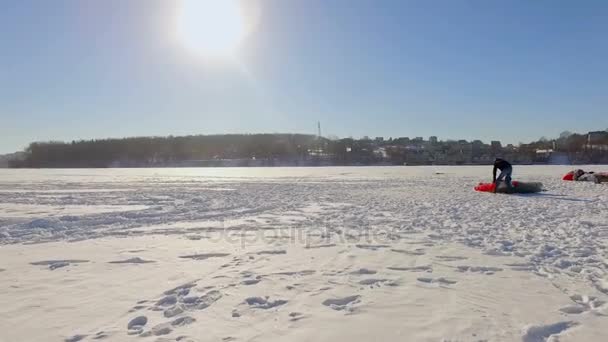 Luftaufnahme. Vorbereitung auf den Winter-Paragliding-Wettbewerb auf einem zugefrorenen See in der Nähe des Stadtparks. — Stockvideo