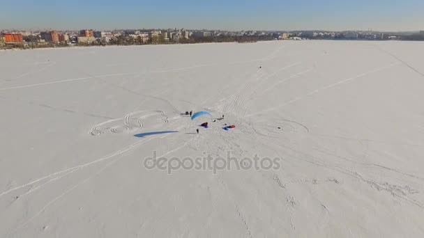 Paisaje invernal. Hermosa vista de la ciudad de invierno y el lago desde una vista de pájaro. preparación de parapentes para las competiciones — Vídeo de stock