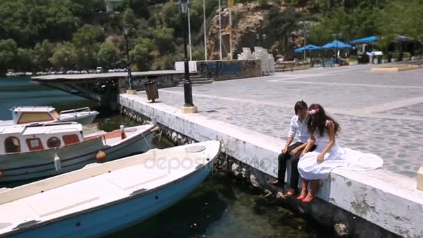 Happy newlyweds sitting at the pier — Stock Video