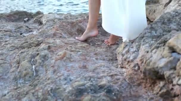 Menina está caindo em uma praia de pedra — Vídeo de Stock