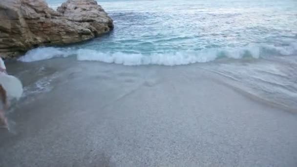 Vacker flicka i en vit klänning på havsstranden åtnjuter havet. — Stockvideo