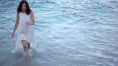 deniz kıyısı üzerinde beyaz elbiseli güzel kız deniz sahiptir. Yunanistan