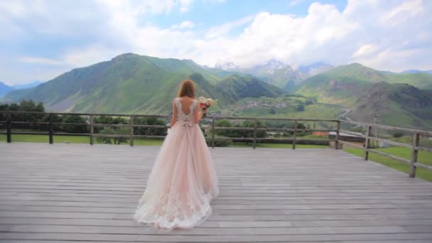 Schöne Mädchen auf dem Hintergrund einer Berglandschaft. Hochzeitstag — Stockvideo