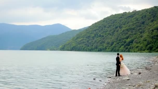 Pareja amorosa en el fondo del río y las montañas — Vídeos de Stock