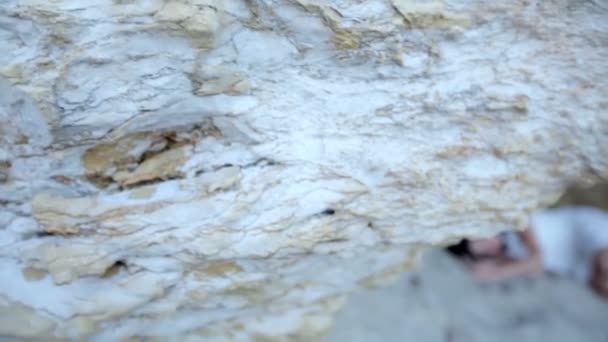 Beautiful girl is sitting on the beach in a stone grotto. Greece. — Stock Video