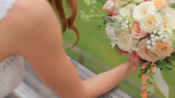 Prachtige roodharige bruid met een boeket van bloemen — Stockvideo