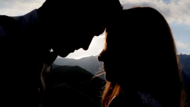 Silhouette of a loving couple on the background of the setting sun, mountains. — Stock Video