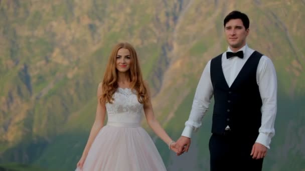 楽しんでと山 ジョージアで手をつないで幸せな新婚夫婦 — ストック動画