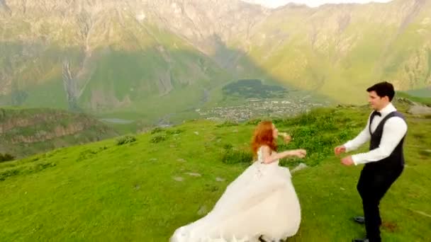 Légi Felvétel Gyönyörű Vörös Hajú Menyasszony Vőlegény Élvezi Hegyek Kazbegi — Stock videók