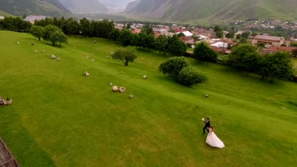 Невеста Жених Бегущие Зеленой Траве Фоне Гор Казбеги Грузия — стоковое видео