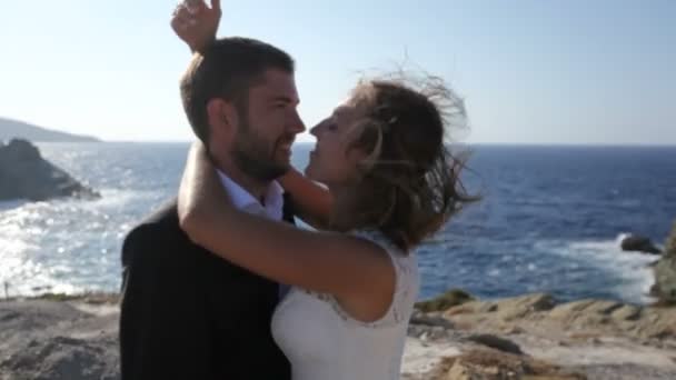 新娘和新郎亲吻 而站在希腊海滩 婚礼日概念 — 图库视频影像