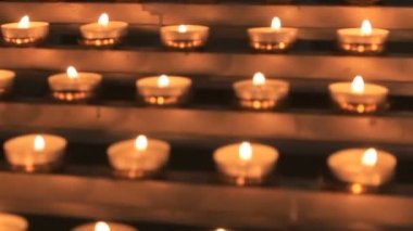 Katolik kilisesinde mihrapta yanan küçük kilise mum kümesi 
