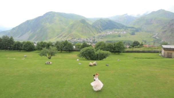 Gelukkig jonggehuwden op een achtergrond van Bergen op hun trouwdag. — Stockvideo