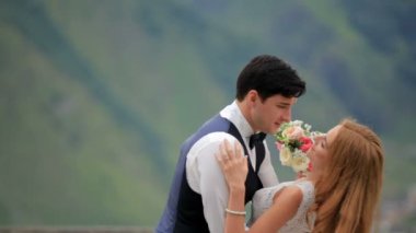 damat ve gelin bir buket ile öpücük sırasında kapalı. Georgia Kazbegi