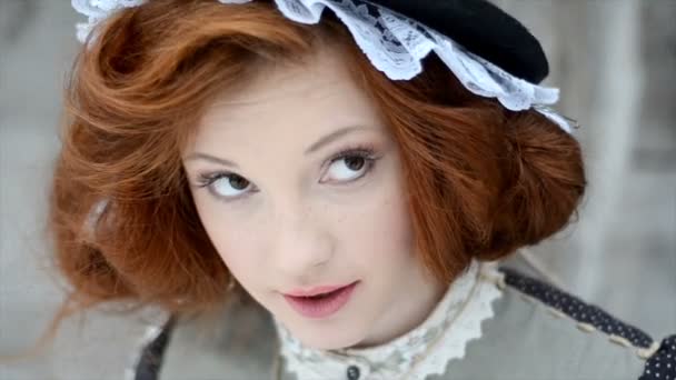 Beautiful red-haired girl in a hat looks up. — Stock Video