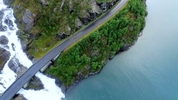 Мощный водопад спускается в реку с горы. Норвегия. Вид с воздуха — стоковое видео