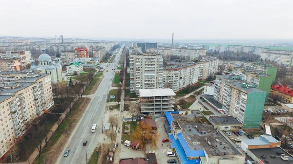 Vista aérea de una calle con casas prefabricadas de varios pisos, una iglesia y una carretera . —  Fotos de Stock