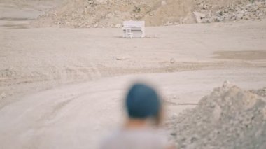 Yabancı elbiseli kız çölde piyanonun arka planında dans ediyor. Sürrealizm.