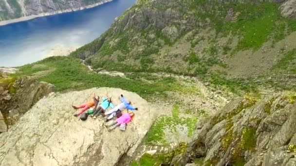 Luchtfoto van een groep toeristen die op de rand van een hoge klif liggen. Trol taal. Noorwegen. Extreem toerisme — Stockvideo