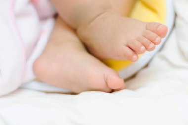 yatakta uyuyan sevimli Asya bebek küçük ayakları