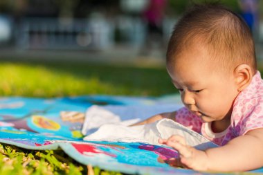  Asya bebek Park'ta zeminde günbatımında yüzükoyun yatıyordu