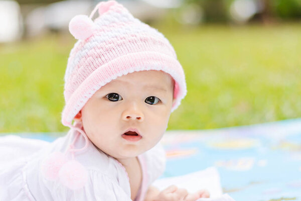  Asian baby lie prone on ground at park