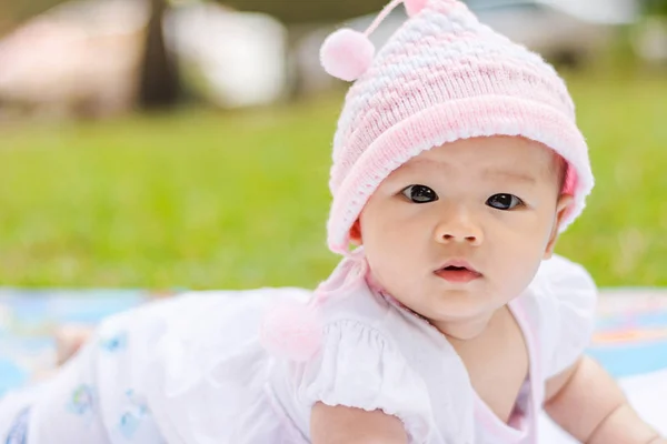 Aziatische baby liggen gevoelig op grond in het park — Stockfoto